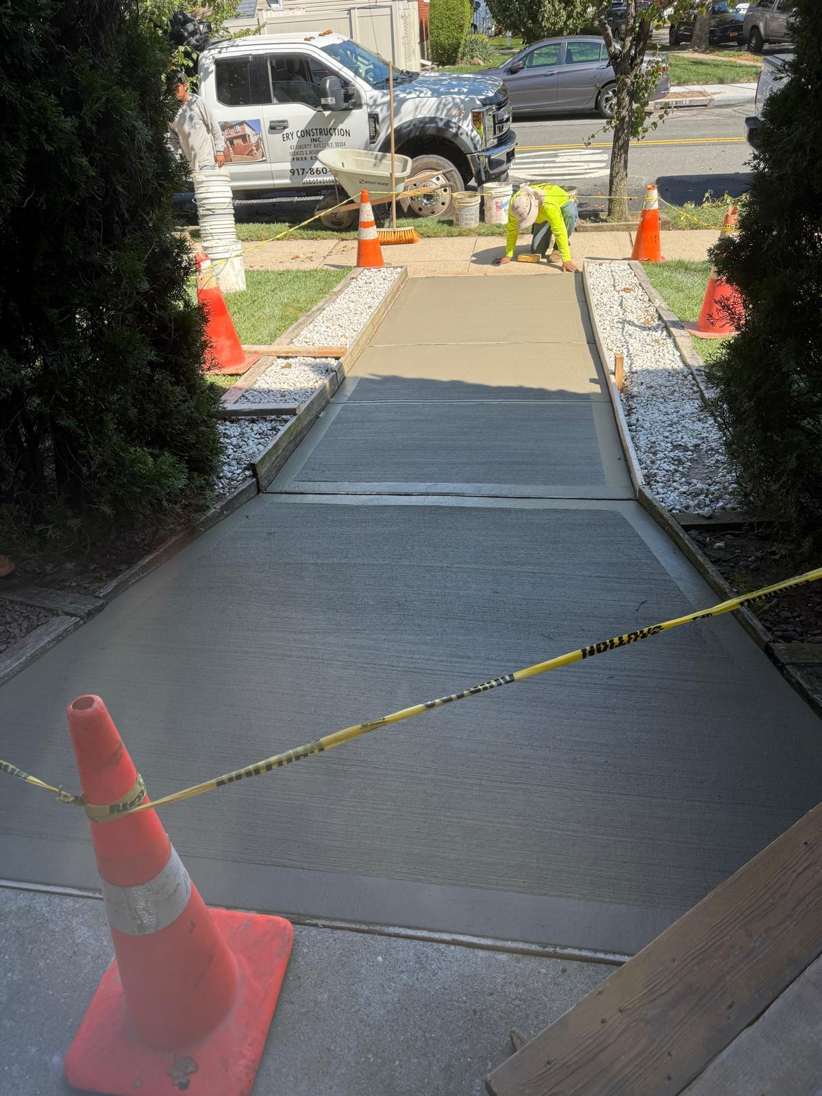 Smooth concrete sidewalk section curing with caution tape